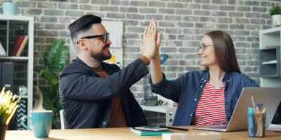 Ein Mann und eine Frau klatschen High Five.